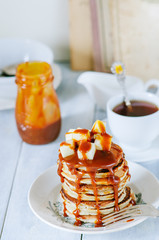 Pancake with apples, salted caramel on a wooden background