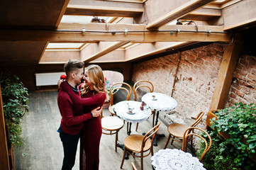 Young beautiful stylish couple in a red dress in love story at t