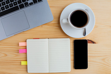 Workplace with laptop, notepad, mobile phone and cup of  coffee