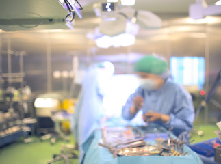 Assistant during surgery in the operating room, defocused backgr