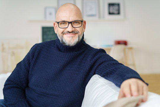 mann mit brille sitzt auf dem sofa im wohnzimmer