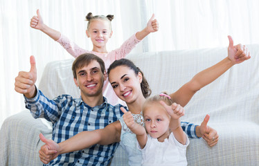 Family values: portrait of parents with little girls indoors
