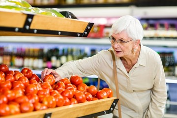 Senior woman choosing her tomatoes