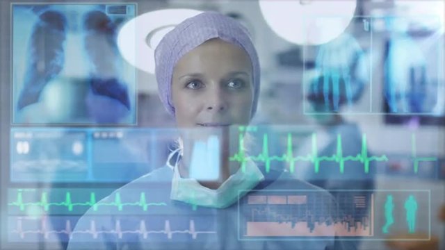 Nurse using Futuristic Analytical Interface in Operating Room. Shot on RED Cinema Camera.