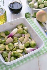 Roasted Brussels Sprouts with Red Onions and Pears in a baking dish white