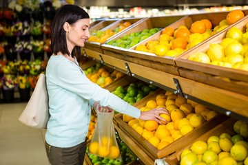 Portrait of a smiling woman buying oranges