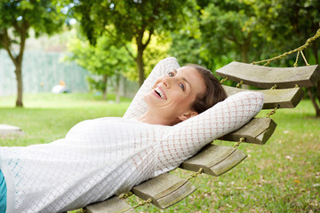 Smiling older woman relaxing on hammock outdoors