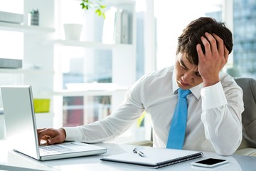 Fototapeta premium Tired asian businessman working at his desk