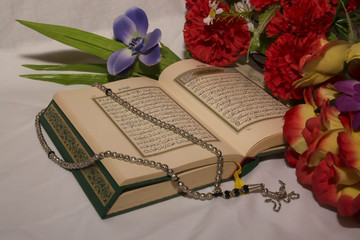 Koran and rosary with flowers