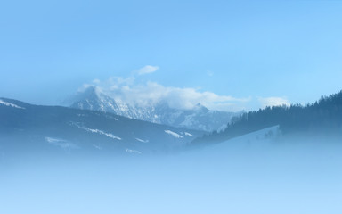 Snowy peaks at foggy morning. The glacier 'Dachstein' is located at the north Alps in Austria. Photo taken from 'Radstadt'.