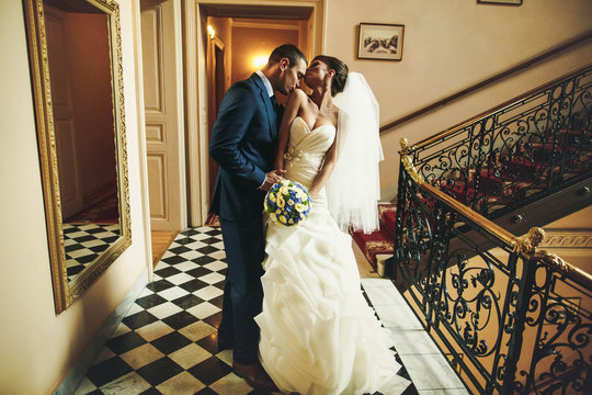 groom is kissing bride shoulder on the  background corridor with