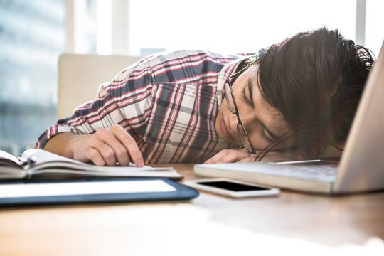 Hipster Businessman Falling Asleep On Desk 