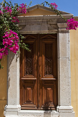 Fototapeta na wymiar old wooden door with bougainvillea flowers