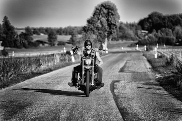 Cool biker with helmet in motion on the road