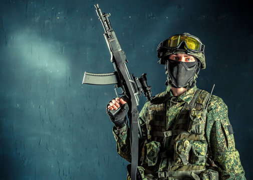 Special forces soldier with rifle on dark background
