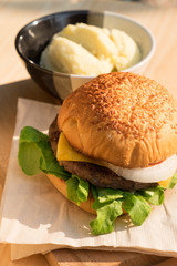 Yummy Beef and cheese Hamburger place on wood tray beside Potato