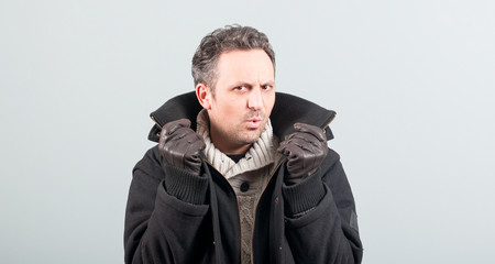Fototapeta premium Sexy man frowning and holding his jacket collar