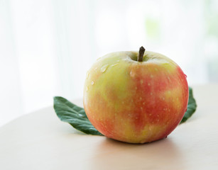 apples with green leaves isolated on light background