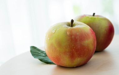 apples with green leaves isolated on light background