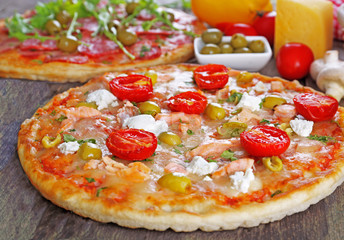 Delicious tasty pizzas with ingredients on table, closeup