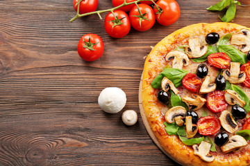 Delicious tasty pizza with ingredients on wooden table