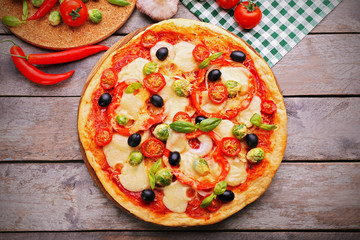 Delicious pizza with cheese and vegetables on wooden background