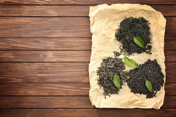 Dry tea with green leaves on wooden table background, copy space