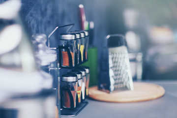 Spices with metal grater on modern kitchen table, close up