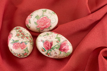 Colorful decoupage decorated Easter eggs on red