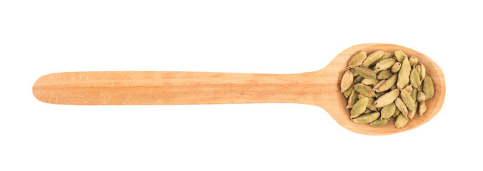 Cardamom seeds in the wooden spoon on white background