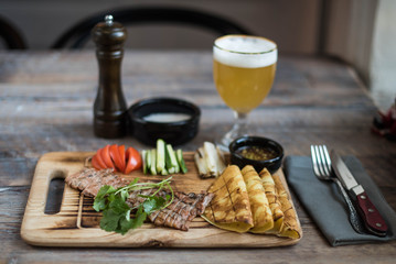 Tasty meat on a board with snacks and beer, top view. Photo for the menu