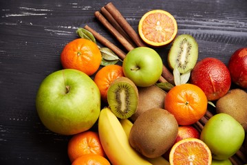 Tropical fruit on black wooden background, top view