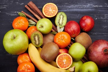 Tropical fruit on black wooden background, top view