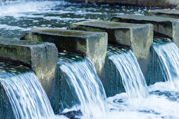 Foto op Plexiglas The water stream flows through a concrete dam © Olga K.