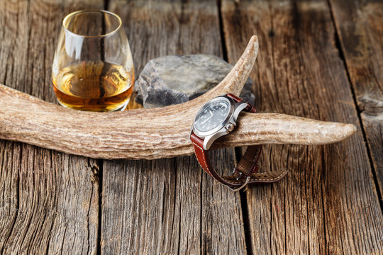 Whiskey glass with watch and deer horn