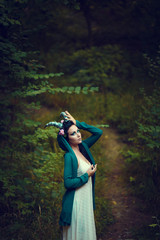 Portrait of a brunette with a floral wreath on her head, horns