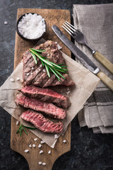 Grilled beef steak with rosemary and salt on cutting board