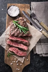 Papier Peint photo Lavable Steakhouse Grilled beef steak with rosemary and salt on cutting board