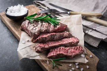 Photo sur Aluminium Steakhouse Steak de boeuf grillé au romarin et sel sur planche à découper