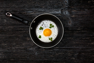 pan with fried eggs on a wooden background