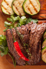 Delicious beef steak with vegetable over wooden table close-up