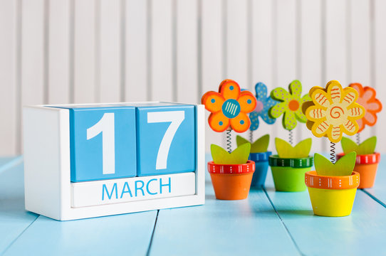 March 17th St. Patrick Day Concept. Image of march 17 wooden color calendar with flower on white background.  Spring day