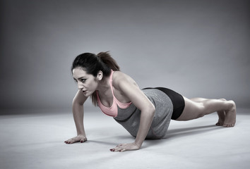 Fototapeta na wymiar Athletic girl doing pushups