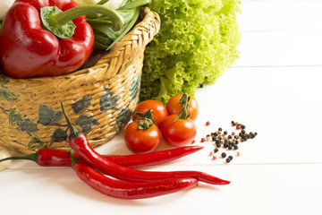 pepper salad vegetables in a wicker basket on a wooden table