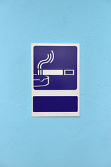 Designated smoking area sign on blue wall of a building