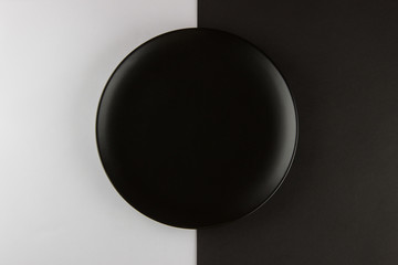 A number of flat plates and cups on black and white background