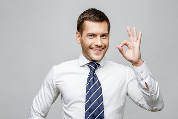 Handsome stylish businessman on grey background