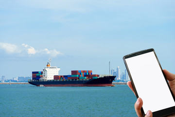 Man hand holding mobile smart phone and Container ship sailing i