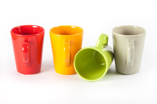 Four color tea cups shown in row, one overturned