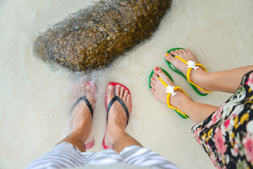 Colorful flipflop sandals on sea beach